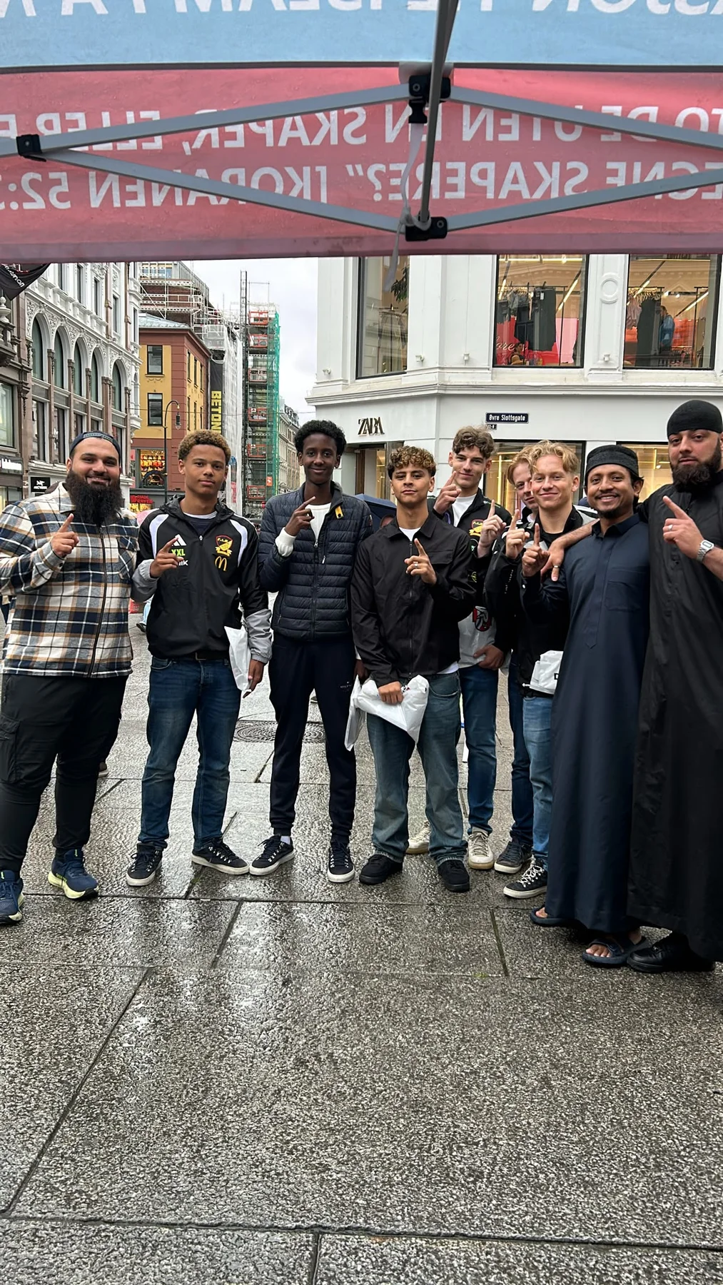 A group standing together under a Dawah Norway information tent